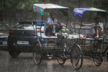 NOIDA, INDIA - 30 Temmuz 2024 'te, nemli bir yazın ardından, akşam yağmuru sırasında Noida, Hindistan' da işe gidip gelenler. (Fotoğraf: Sunil Ghosh / Hindustan Times 