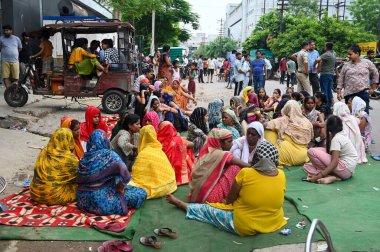 NOIDA, INDIA - 31 Temmuz 2024 'te Hindistan' ın Noida kentinde, Sektör 8 'deki bir evde çıkan yangında aynı aileden üç çocuk öldükten sonra, evin önünde oturan aile üyeleri. Polise göre, itfaiye teşkilatı... 