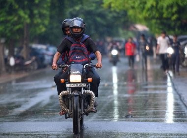 NOIDA, INDIA - 30 Temmuz 2024 'te, nemli bir yazın ardından, akşam yağmuru sırasında Noida, Hindistan' da işe gidip gelenler. (Fotoğraf: Sunil Ghosh / Hindustan Times 