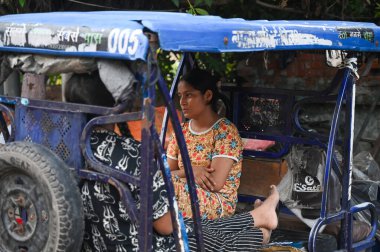 NOIDA, INDIA - 31 Temmuz 2024 'te Hindistan' ın Noida kentinde, Sektör 8 'deki bir evde çıkan yangında aynı aileden üç çocuk öldükten sonra, evin önünde oturan aile üyeleri. Polise göre, itfaiye teşkilatı... 