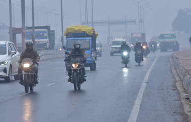 GHAZIABAD, INDIA - 31 Ocak 2024 'te Hindistan' ın Gaziabad kentindeki NH9 Dasna 'da bir hafif yağmur büyüsünün Gaziabad şehrini çarşamba gününden beri süpürmesiyle, banliyö sakinleri zorlu sürüş koşullarıyla karşı karşıya kaldı. Delhi 'de soğuk bir günde hafif yağmur vardı.