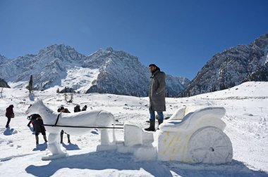 SRINAGAR, INDIA  FEBRUARY 10, 2024: A view of a Snow Horse Cart sculpture built on the slopes of Sonamarg, on February 10, 2024 in Srinagar, India. The statue shows a horse pulling a cart through the snow. clipart