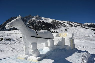 SRINAGAR, INDIA  FEBRUARY 10, 2024: A view of a Snow Horse Cart sculpture built on the slopes of Sonamarg, on February 10, 2024 in Srinagar, India. The statue shows a horse pulling a cart through the snow. clipart