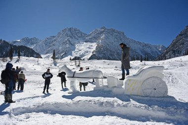 SRINAGAR, INDIA  FEBRUARY 10, 2024: A view of a Snow Horse Cart sculpture built on the slopes of Sonamarg, on February 10, 2024 in Srinagar, India. The statue shows a horse pulling a cart through the snow. clipart