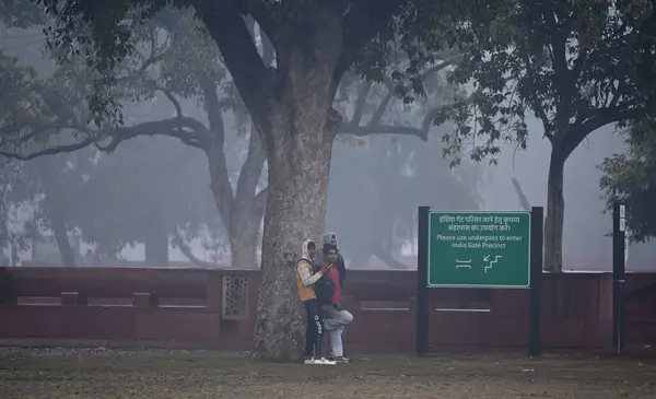 stock image NEW DELHI, INDIA - JANUARY 31: Visitors protect themselves from sudden rain at Kartavya Path, on January 31, 2024 in New Delhi, India.