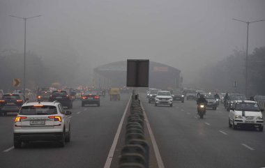 GURUGRAM, INDIA JANUARY 24: Gurugram-Sohna 'da seyahat ederken sıcak kıyafetler giydikleri görülen banliyö sakinleri, 24 Ocak 2024' te Hindistan 'ın Gurugram kentinde, Hava Üssü yakınlarındaki soğuk ve sisli kış sabahında ekspres yolda yükseldiler.