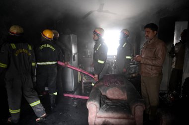 NOIDA, INDIA JANUARY 14, 2024: Bir evin içindeki yangını söndürmeye çalışan bir itfaiye ekibi ve 25. Sektördeki üç kişinin kurtarılması