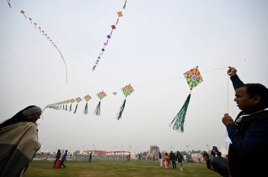 NEW DELHI, INDIA JANUARY 13, 2024: İlk uluslararası uçurtma festivalinde insanlar uçurtma uçuruyor- Patang Utsav Baansera 'da Delhi LG VK Saxena' nın açılışında, Sarai Kale Khan nehrinin kıyısındaki ilk bambu temalı parkı