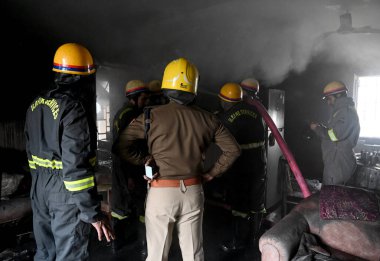 NOIDA, INDIA JANUARY 14, 2024: Bir evin içindeki yangını söndürmeye çalışan bir itfaiye ekibi ve 25. Sektördeki üç kişinin kurtarılması
