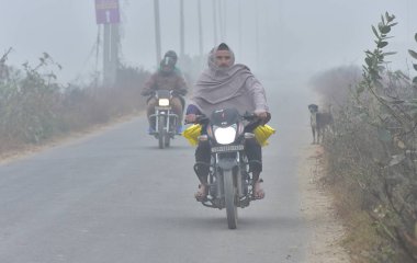 GHAZIABAD, INDIA  JANUARY 3, 2024: Commuters out a cold and Fog morning amid rising air pollution levels at naiphal road delhi meerut expressway dasna clipart