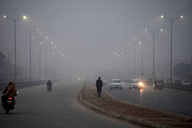 GURUGRAM, INDIA JANUARY 11, 2024: Yoğun bir sis tabakası Umang Bhardwaj Boğazı yakınlarındaki 10a sektöründe bir yolu yutuyor