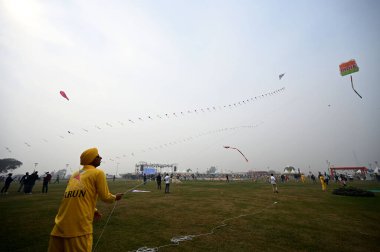 NEW DELHI, INDIA JANUARY 13, 2024: İlk uluslararası uçurtma festivalinde insanlar uçurtma uçuruyor- Patang Utsav Baansera 'da Delhi LG VK Saxena' nın açılışında, Sarai Kale Khan nehrinin kıyısındaki ilk bambu temalı parkı