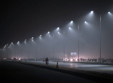 NEW DELHI, INDIA HAZİRAN 3, 2024: Araçlar kış sabahları Dwarka, Güney Batı Delhi 'de serin ve sisli bir havada hareket eder