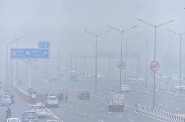 GHAZIABAD, INDIA JANUARY 3, 2024: Naiphal karayolu delhi meerut ekspres yolu dasna 'da yükselen hava kirliliği seviyeleri arasında banliyö sakinleri soğuk ve sisli bir sabah