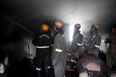 NOIDA, INDIA JANUARY 14, 2024: Bir evin içindeki yangını söndürmeye çalışan bir itfaiye ekibi ve 25. Sektördeki üç kişinin kurtarılması
