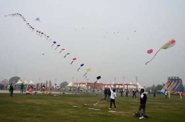 NEW DELHI, INDIA JANUARY 13, 2024: İlk uluslararası uçurtma festivalinde insanlar uçurtma uçuruyor- Patang Utsav Baansera 'da Delhi LG VK Saxena' nın açılışında, Sarai Kale Khan nehrinin kıyısındaki ilk bambu temalı parkı