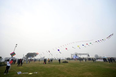 NEW DELHI, INDIA JANUARY 13, 2024: İlk uluslararası uçurtma festivalinde insanlar uçurtma uçuruyor- Patang Utsav Baansera 'da Delhi LG VK Saxena' nın açılışında, Sarai Kale Khan nehrinin kıyısındaki ilk bambu temalı parkı