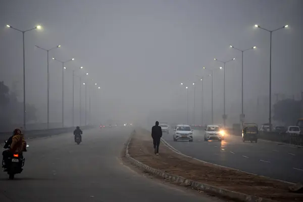 stock image GURUGRAM, INDIA  JANUARY 11, 2024: A thick layer of dense fog engulfs at a road in sector-10a near Umang Bhardwaj chowk