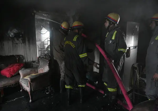 stock image NOIDA, INDIA  JANUARY 14, 2024: A team of Firefighters trying to extinguish a fire gutted inside a house along with rescuing three people in Sector 25