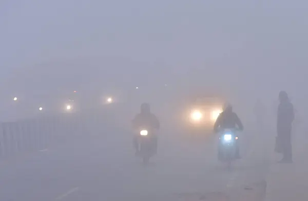 stock image GHAZIABAD, INDIA  JANUARY 14, 2024: Vehicles moving slowly amid dense fog at NH9, Mehrauli on January 14, 2024 in Ghaziabad, India. Foggy morning challenges Delhi-NCR with intensifying cold wave, mercury dips further across North India. 