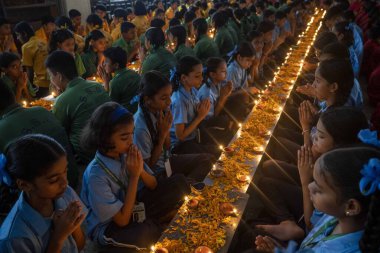 MUMBAI, INDIA - 3 Ağustos 2024 'te Mumbai, Hindistan' da Shivaji Eğitim Enstitüsü 'nden öğrenciler Ashadha Amavasya' da düzenlenen Derin Puja törenine katılarak 800 'den fazla lambayı yakarak konsantrasyonu artırdı.. 