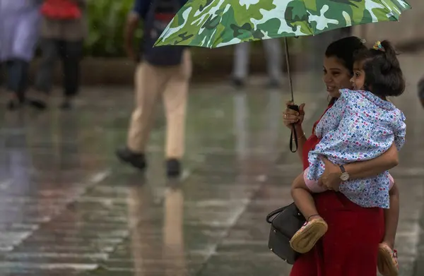 stock image MUMBAI, INDIA - AUGUST 3, 2024: People going through the rain at Vikhroli, on August 3, 2024 in Mumbai, India. 