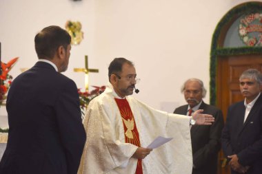 GURUGRAM, INDIA - 25 Aralık 2023 'te Hindistan' ın Gurugram kentindeki Sivil Hatlar 'da düzenlenen Noel kutlamaları sırasında Hristiyan bir rahip Epifani Kilisesi' nde dua ediyor.. 