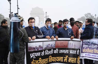 NEW DELHI, INDIA - 30 Aralık 2023 'te Hindistan Kapısı yakınında oksijen maskesi takan BJP çalışanları Delhi CM Arvind Kejriwal liderliğindeki eyalet hükümetine ve 30 Aralık 2023' te Yeni Delhi, Hindistan 'da hava kirliliğinin artmasına karşı protesto düzenlediler..  
