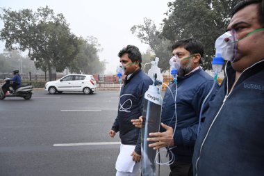 NEW DELHI, INDIA - 30 Aralık 2023 'te Hindistan Kapısı yakınında oksijen maskesi takan BJP çalışanları Delhi CM Arvind Kejriwal liderliğindeki eyalet hükümetine ve 30 Aralık 2023' te Yeni Delhi, Hindistan 'da hava kirliliğinin artmasına karşı protesto düzenlediler..  