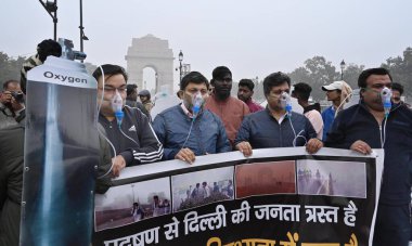 NEW DELHI, INDIA - 30 Aralık 2023 'te Hindistan Kapısı yakınında oksijen maskesi takan BJP çalışanları Delhi CM Arvind Kejriwal liderliğindeki eyalet hükümetine ve 30 Aralık 2023' te Yeni Delhi, Hindistan 'da hava kirliliğinin artmasına karşı protesto düzenlediler..  