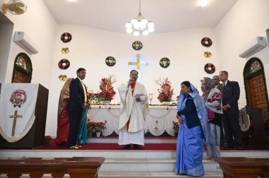 GURUGRAM, INDIA - 25 Aralık 2023 'te Hindistan' ın Gurugram kentindeki Sivil Hatlar 'da düzenlenen Noel kutlamaları sırasında Hristiyan bir rahip Epifani Kilisesi' nde dua ediyor.. 