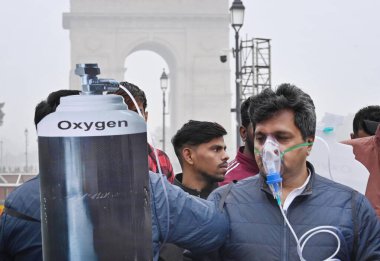NEW DELHI, INDIA - 30 Aralık 2023 'te Hindistan Kapısı yakınında oksijen maskesi takan BJP çalışanları Delhi CM Arvind Kejriwal liderliğindeki eyalet hükümetine ve 30 Aralık 2023' te Yeni Delhi, Hindistan 'da hava kirliliğinin artmasına karşı protesto düzenlediler..  
