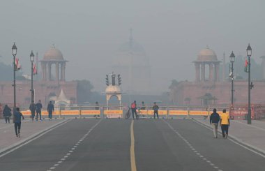 NEW DELHI, INDIA 17 ARALIK 2023: Hindistan Kapısı yakınlarındaki Kartavya Yolu 'nda soğuk ve sisli bir sabahta sabah yürüyüşçüleri 