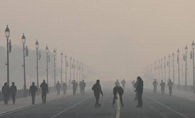 NEW DELHI, INDIA 17 ARALIK 2023: Hindistan Kapısı yakınlarındaki Kartavya Yolu 'nda soğuk ve sisli bir sabahta sabah yürüyüşçüleri 