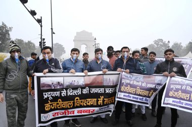 NEW DELHI, INDIA - 30 Aralık 2023 'te Hindistan Kapısı yakınında oksijen maskesi takan BJP çalışanları Delhi CM Arvind Kejriwal liderliğindeki eyalet hükümetine ve 30 Aralık 2023' te Yeni Delhi, Hindistan 'da hava kirliliğinin artmasına karşı protesto düzenlediler..  