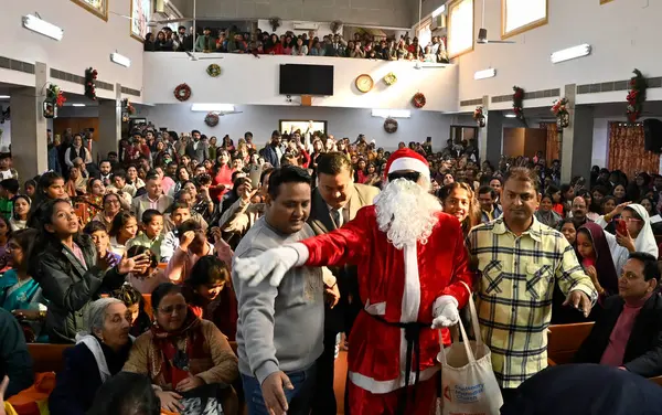 stock image NEW DELHI, INDIA - DECEMBER 25, 2023: A man dressed as Santa Claus distributes candies during Christmas celebrations at Centenary Methodist Church, Lodhi Road, on December 25, 2023 in New Delhi, India.