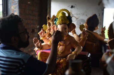 NAVI MUMBAI, INDIA - AUGUST 8: A village hamrapur Pen artist giving finishing touches to Hindu God Ganpati idols ahead Ganesh Chaturthi festival at Pen  on August 8, 2023 in Navi Mumbai, India. clipart