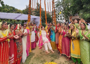 AMRITSAR, INDIA - AUGUST 14, 2023: Staff members and Students perform Gidha during Teej festival celebrations at Khalsa College For Women on August 14, 2023 in Amritsar, India clipart