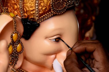 NAVI MUMBAI, INDIA - AUGUST 8: A village hamrapur Pen artist giving finishing touches to Hindu God Ganpati idols ahead Ganesh Chaturthi festival at Pen  on August 8, 2023 in Navi Mumbai, India. clipart