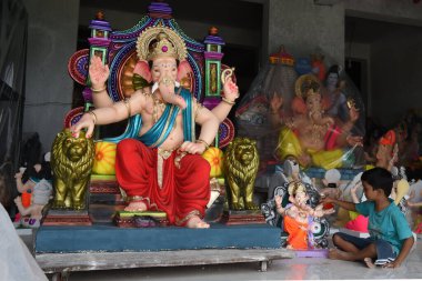 NAVI MUMBAI, INDIA - 8 Ağustos 2023 'te Hindistan' ın Navi Mumbai kentinde düzenlenen Pen 'de Ganesh Chaturthi festivali öncesinde Hindu tanrı Ganpati putlarına son rötuşları yapan bir köy hamur kalemi sanatçısı.
