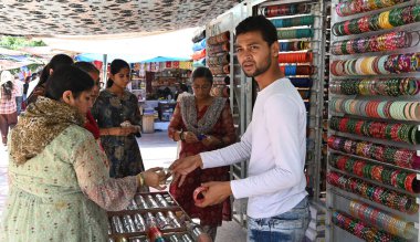 NEW DELHI, INDIA - 6 Ağustos 2024 'te Hindistan' ın Yeni Delhi kentinde 6 Ağustos 2024 'te CP' de Sawan Teej festivali için Bangles haykıran Hintli kadın ve kız. 