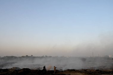 NEW DELHI, INDIA 19 Mayıs: 30. Sektör 'deki boş bir arsada meydana gelen yangın, Perşembe akşamı boyunca devam etti ve yakınlardaki bölge sakinlerini boğulma, gözlerinde yanma hissi bıraktı.