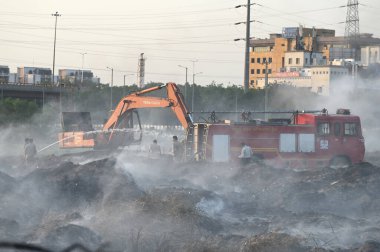 NEW DELHI, INDIA 19 Mayıs: 30. Sektör 'deki boş bir arsada meydana gelen yangın, Perşembe akşamı boyunca devam etti ve yakınlardaki bölge sakinlerini boğulma, gözlerinde yanma hissi bıraktı.