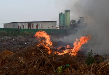 NEW DELHI, INDIA 19 Mayıs: 30. Sektör 'deki boş bir arsada meydana gelen yangın, Perşembe akşamı boyunca yanmaya devam ederek yakınlardaki bölge sakinlerini boğulma ve gözlerinde yanma hissi bıraktı.