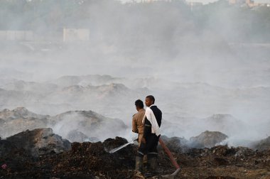 NEW DELHI, INDIA 19 Mayıs: 30. Sektör 'deki boş bir arsada meydana gelen yangın, Perşembe akşamı boyunca devam etti ve yakınlardaki bölge sakinlerini boğulma, gözlerinde yanma hissi bıraktı.