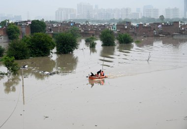 NEW DELHI, INDIA - 13 Temmuz Perşembe günü Yeni Delhi, Hindistan 'daki Jaitpur khadda kolonisinde şiddetli muson yağmurları sonrasında NDRF personeli Yamuna Nehri' nin taşkın sularından insanları kurtardı..