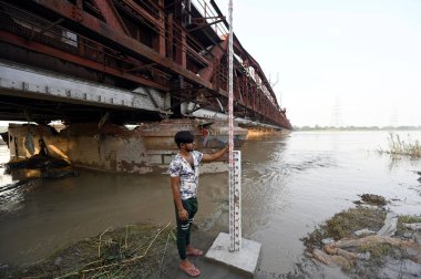 NEW DELHI, INDIA - 26 Temmuz 2023 'te Yeni Delhi, Hindistan' da Yamuna su geçişi sonrasında su seviyesini kontrol eden Merkez Su Komisyonu çalışanları. 