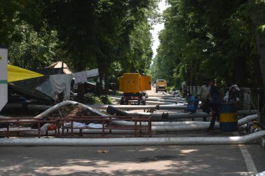 NEW DELHI, INDIA 22 Temmuz 2023: Yeni Delhi, Hindistan 'da su temizleyen işçiler, kaldırımların ve peyzajın restorasyonunu, 22 Temmuz 2023 tarihinde. 