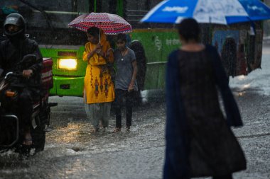 NEW DELHI, INDIA - 10 Temmuz 2023 'te Hindistan' ın Yeni Delhi kentinde şiddetli yağmurların şehri kasıp kavurmasından sonra, banliyö sakinleri su dolu bir caddede hareket ediyor.. 