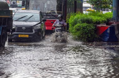 NEW DELHI, INDIA - 10 Temmuz 2023 'te Hindistan' ın Yeni Delhi kentinde şiddetli yağmurların şehri kasıp kavurmasından sonra, banliyö sakinleri su dolu bir caddede hareket ediyor.. 